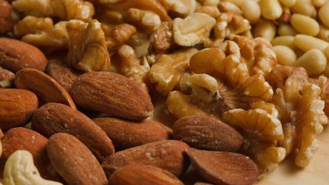 Nuts mix of pecan walnut cashew hazelnut pine and Brazil nuts with peanut on wooden table healthy snack close-up