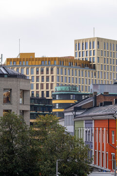 Modern architecture in Oslo rises behind traditional buildings as colorful facade details and urban skyline layers define the Norwegian city center