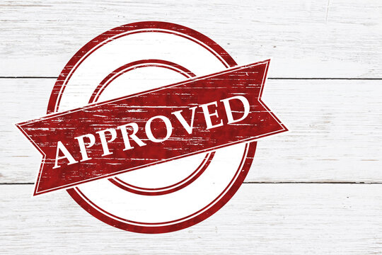 Red distressed Approved stamp on weathered wood for passing quality control