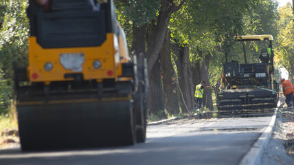 Naklejka premium Road Roller and Paver Distorted by Heat Haze from Hot Asphalt