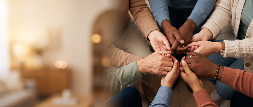 Diverse group of hands coming together in a circle on a table  