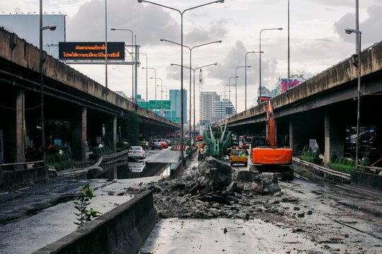 Construction workers working on an expressway demolition on cloudy day