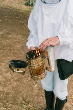 Bee farming. Female beekeeper prepares for the bee inspection