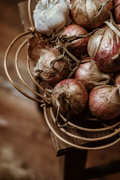Bowl of Onions and Garlic on a Wooden Table