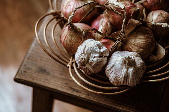 Bowl of Onions and Garlic on a Wooden Table