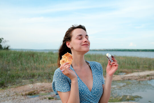 Woman enjoying a snack after a day by the water