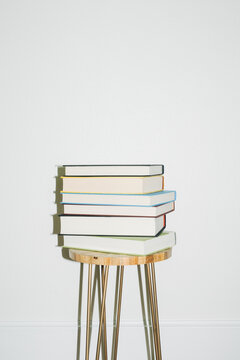 Stack of Books on Side Table, White Wall