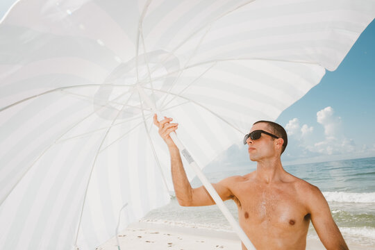 Man in Sunglasses Opening Beach Umbrella