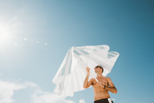 Opening Beach Umbrella Under Blue Sky
