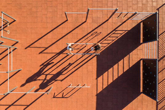 Terracotta playground shadows with monkey bars in aerial top down view