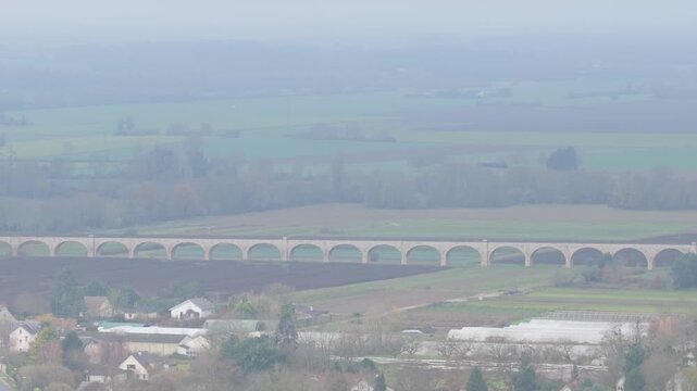 The Pont du Chemin de Fer railway bridge spanning across the countryside and river near Gien, France, aerial view.