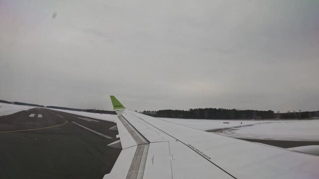 RIGA, LATVIA - FEBRUARY 10, 2024: AirBaltic plane taking off on snowy runway at Riga Airport in winter