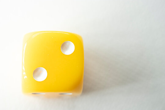 Bright yellow die showing number two The Concept of luck and chance