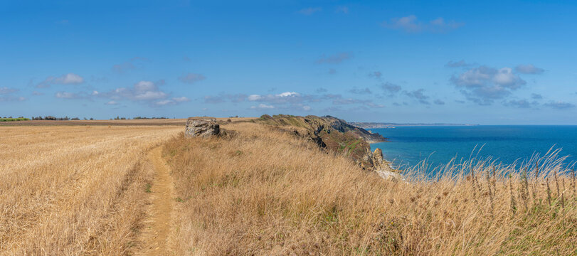 Arromanches-les-Bains, France - 08 10 2026: Coastal path. Panoramic view of the cliffs, the sea and cloudy sky from top of the path