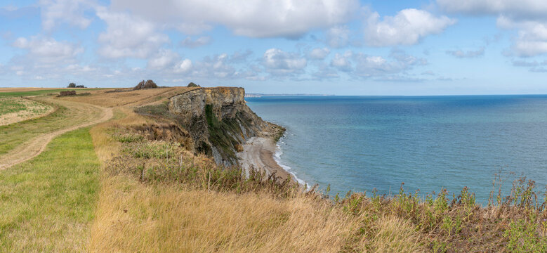 Arromanches-les-Bains, France - 08 10 2026: Coastal path. Panoramic view of the cliffs, the sea and cloudy sky from top of the path