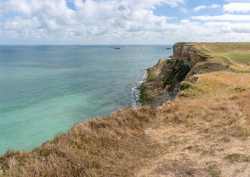 Arromanches-les-Bains, France - 08 10 2026: Coastal path. Panoramic view of the cliffs, the sea and cloudy sky from top of the path