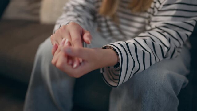 Close-up of teenage girl's hands cracking her fingers, illustrating nervous habits, stress, tension and emotional discomfort.