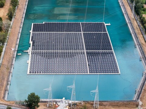 Aerial view of a floating solar farm on a hydroelectric reservoir, designed to generate renewable energy and reduce water evaporation in Venaus, Piedmont, Italy.