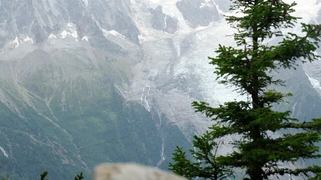 Brevent cable car cabin moving against Glacier des Bossons background in Chamonix Mont Blanc valley, famous alpine cableway public transport in French Alps mountain landscape during summer travel