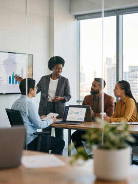Diverse team review data analytics in modern office meeting