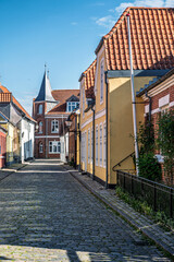 Fototapeta premium A quiet cobblestone street lined with traditional colorful houses in the historic town of Ribe, Denmark.