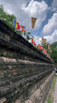 Ancient Stone Wall with Buddhist Flags at Sri Dalada Maligawa in Kandy, Sri Lanka