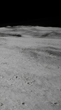 The surface of the moon. There are low hills and craters across the land. The dark sky surrounds the landscape creating a stark view of the moon.