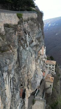 Dramatic view of the Madonna della Corona Sanctuary built into a sheer limestone cliff above the Adige Valley in northern Italy