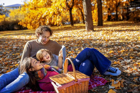 Happy family posing with a picnic basket in autumn