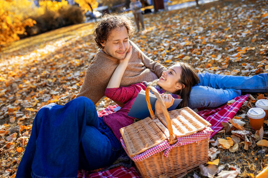 Smiling mother cuddling son behind a picnic basket