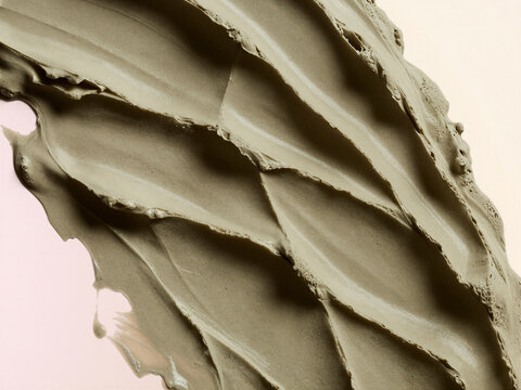 Macro Texture of Creamy Sage Green Clay Face Mask Smeared on Light Background