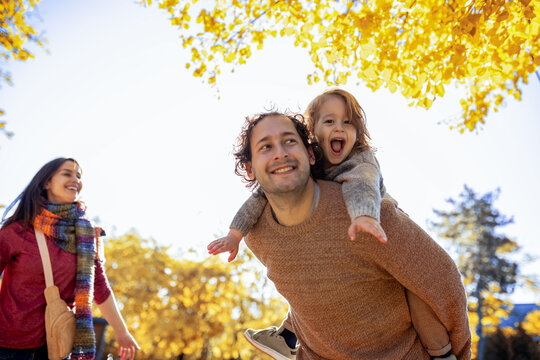 Low angle portrait of father and son on his back
