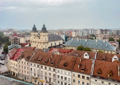 Panoramic view of European city skyline with historic church and modern buildings under cloudy sky