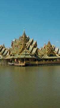 Ornate Thai temple with green and gold roofs built over calm water in Ancient City, Bangkok city, Thailand. Pavilion of the Enlightened in Ancient Siam. Travel destination in Asia