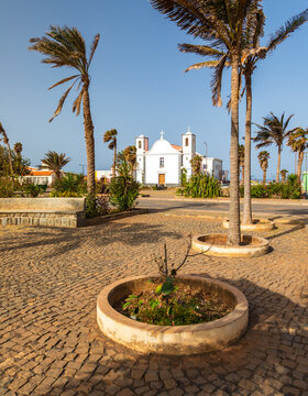 View of the white church in the town square with palm trees and cobblestone ground in Ponta do Sol, Santo Antao, Cape Verde.