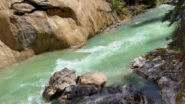Johnston Creek river in Johnston Canyon in the Banff National Park. British Columbia, Canada. A flowing river moves through rocky terrain, highlighting the vibrant turquoise water and natural beauty o