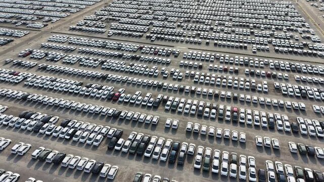 Aerial view of a vast parking lot filled with rows of new cars waiting for distribution at a logistics facility in Chennai, Tamil Nadu, India.