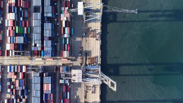 Aerial view of rows of colorful shipping containers and port cranes at the busy container terminal in Chennai, Tamil Nadu, India.