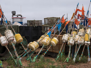 Marker buoys with orange flags and octopus traps stored at a fishing harbour, Portugal © Svetlana