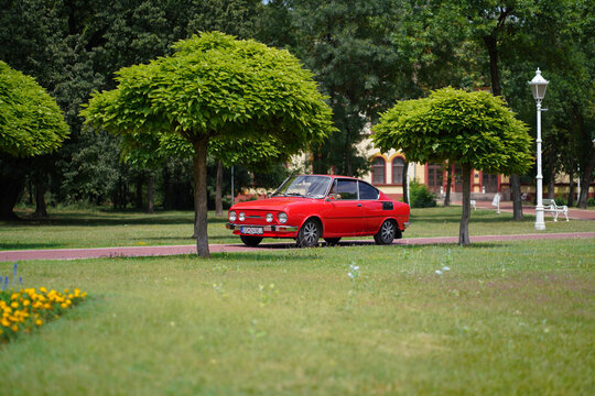 Red Skoda 110 R Coupe classic oldtimer car (east-european Corvair) front three quarter view driving on scenic path between green trees, Palic, Serbia, July 5, 2026