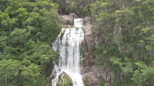Aerial view of the cascading waterfall surrounded by lush green forest in Chapada dos Veadeiros, Alto Paraiso de Goias, Goias, Brazil.