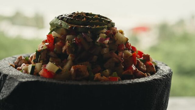Traditional peruvian ceviche with fresh fish, avocado, tomato, and onion in a stone bowl