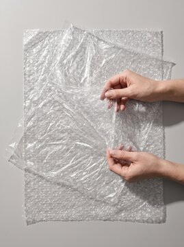 Wrinkled cellophane film and bubble wrap on gray background, packaging plastic texture overlay, abstract transparent material