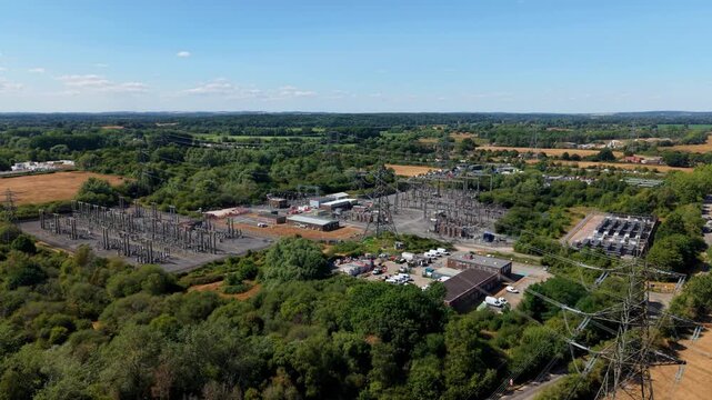 Aerial view of the National Grid Nursling Substation featuring electrical infrastructure, transformers, and power lines surrounded by lush greenery in Nursling, England, United Kingdom.