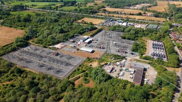 Aerial view of the Nursling Substation electrical infrastructure with transformers and power lines surrounded by lush greenery in Nursling, England, United Kingdom.