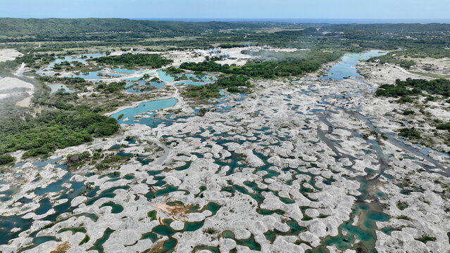 Aerial view of Balneario La Neverita featuring turquoise pools of water amidst a rocky landscape with lush green vegetation in Nizao, Peravia Province, Dominican Republic.