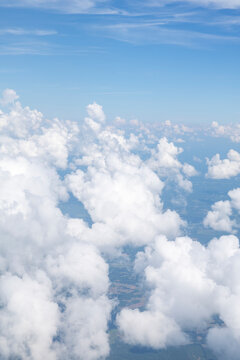 White, puffy clouds against a blue sky from an airplane