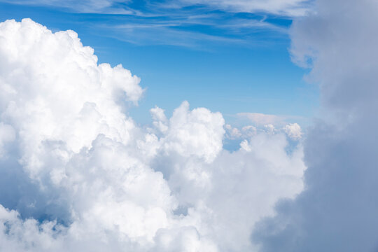 White, puffy clouds against a blue sky from an airplane