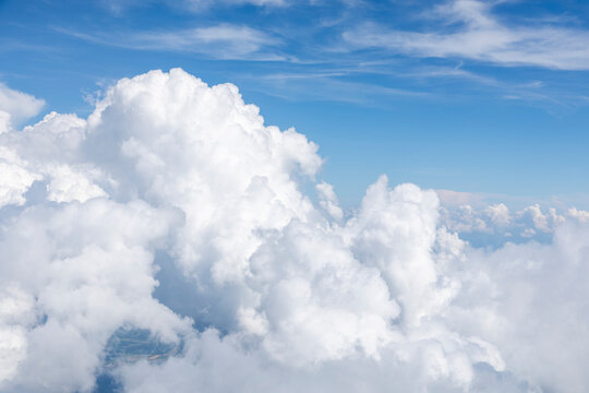 White, puffy clouds against a blue sky from an airplane