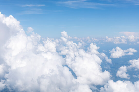 White, puffy clouds against a blue sky from an airplane
